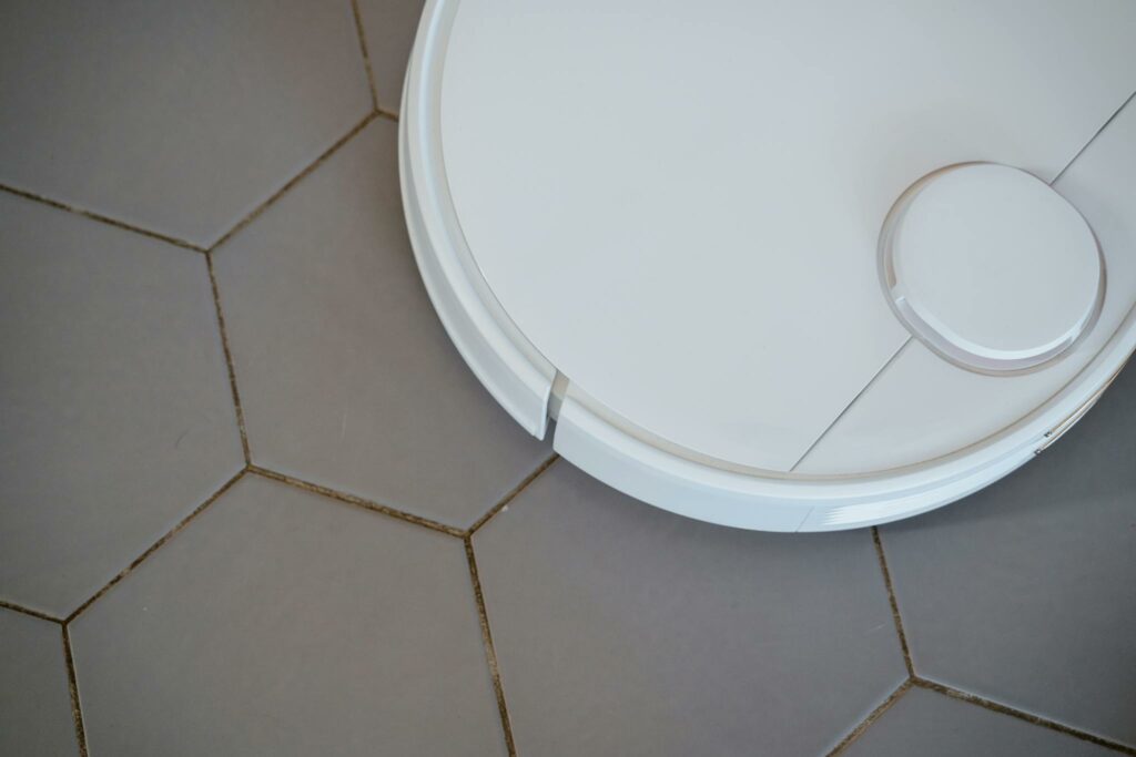 Close-up of a robotic vacuum cleaner on hexagonal tiles for efficient cleaning.